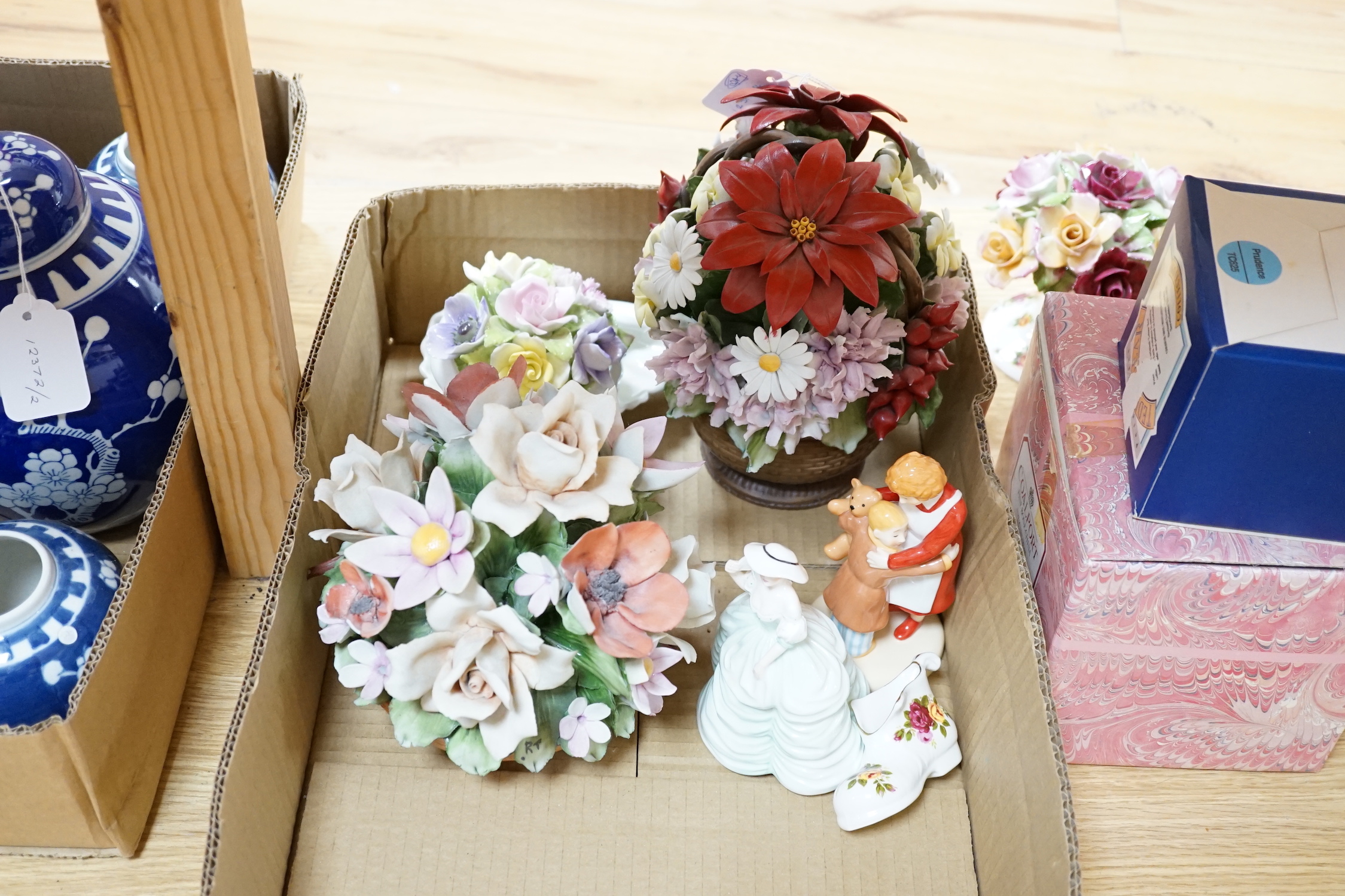 A small group of figurines and decorative ceramics, including four floral ceramic table displays